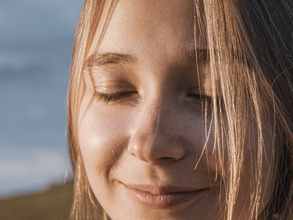 Woman with natural, rested skin in golden light